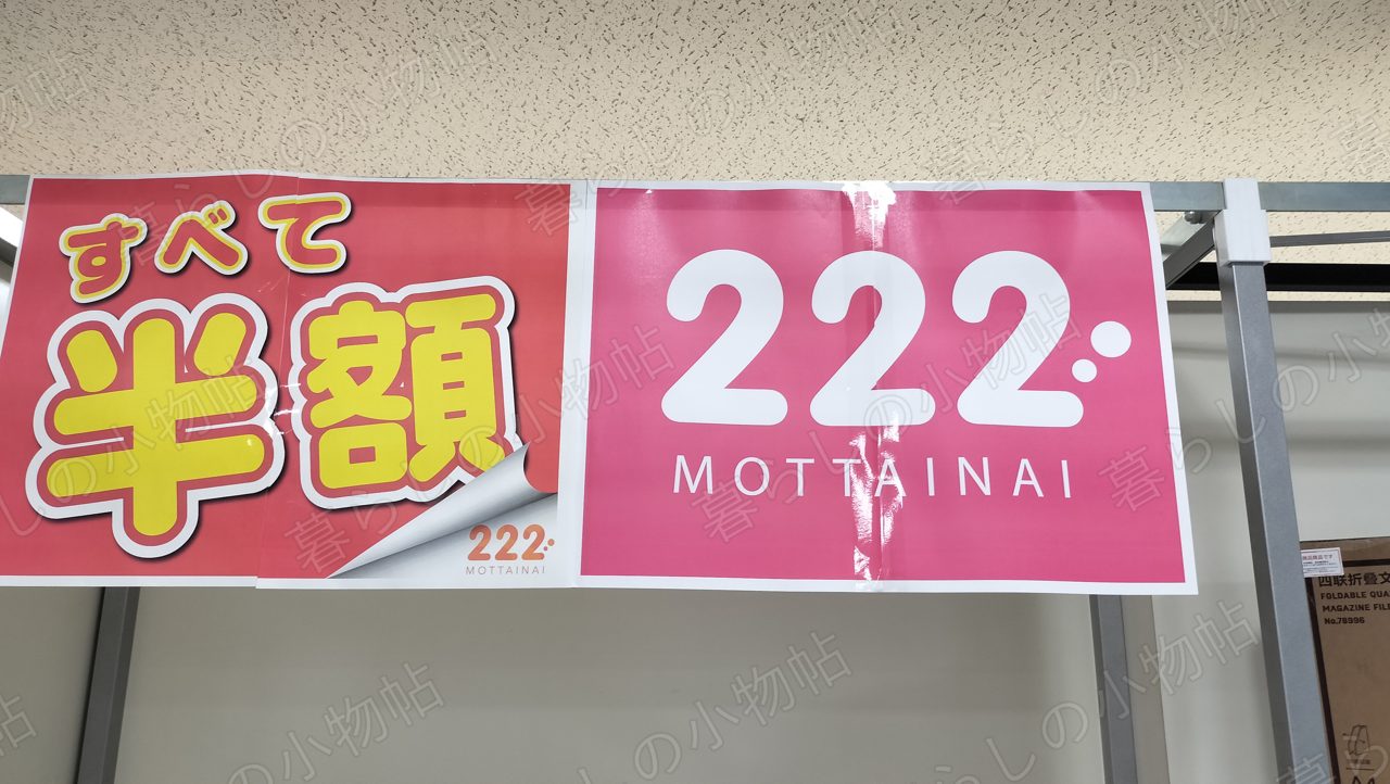「すべて半額 222 MOTTAINAI」と書かれたピンクの横断幕を店内で撮影