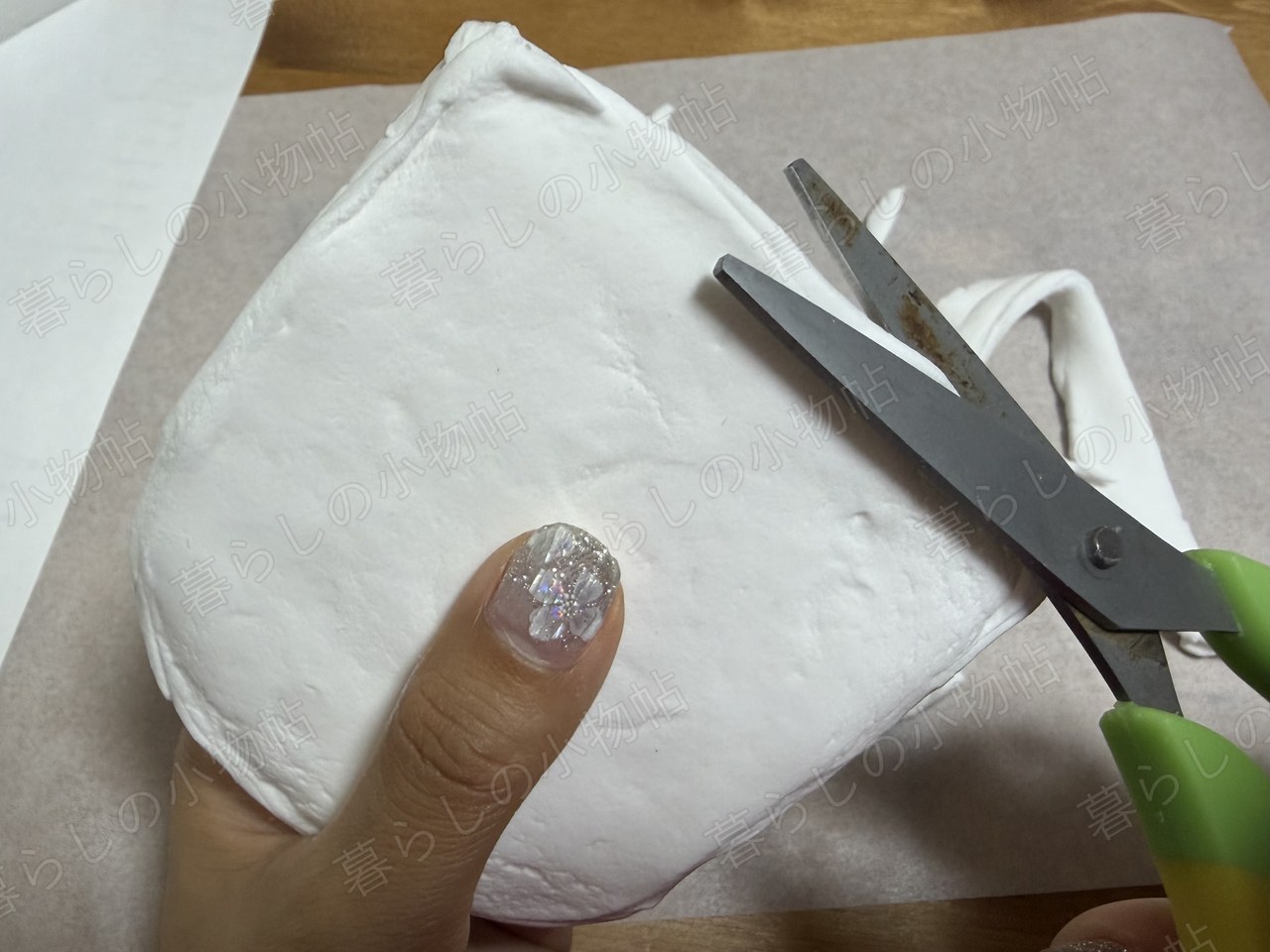 スポンジに粘土をかぶせて、はみ出た余分をハサミで切っているところ