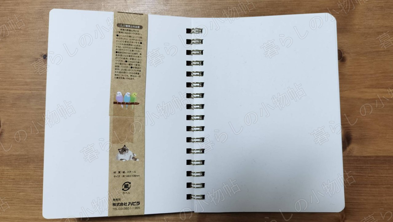 シール帳を開いた裏面。スパイラルリングと、材質・サイズなどが書かれた仕様の帯