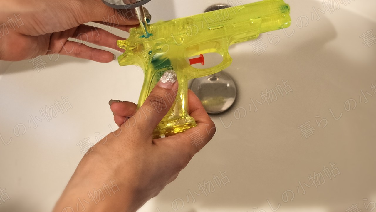 蛇口から出した水を水鉄砲のタンクへ入れているところ