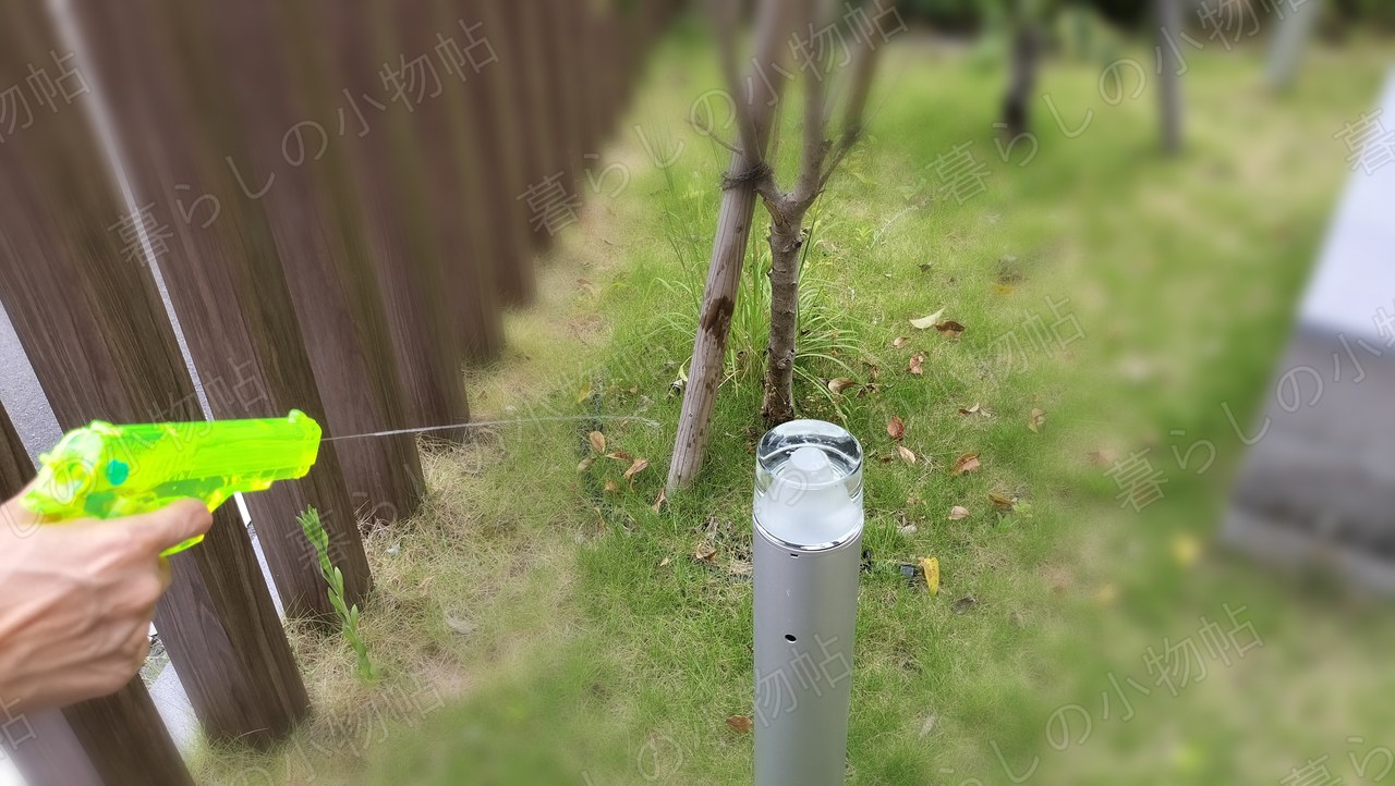 庭のライトをねらって水鉄砲を撃ち、水が線になってのびているところ