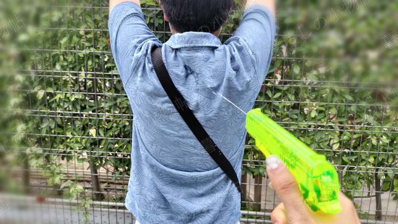 水鉄砲の水が家族の背中に当たっているところ