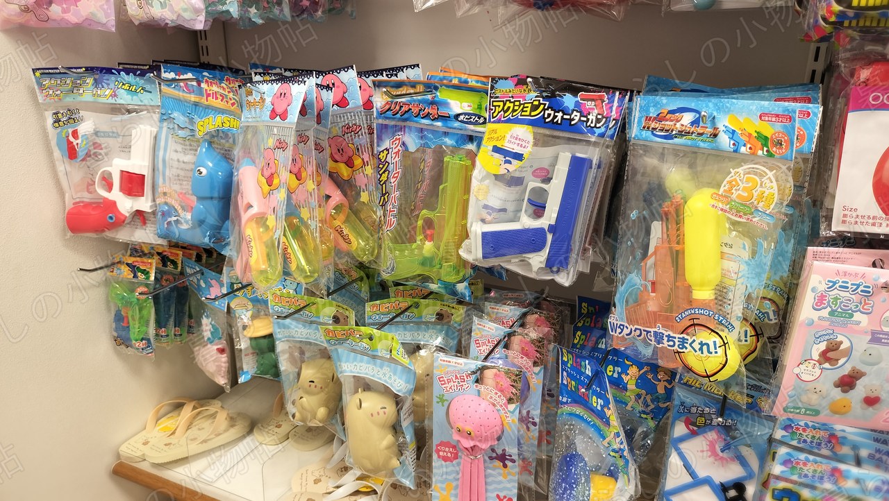 セリアの水鉄砲売り場。ピストル型やキャラクター物の水鉄砲が並ぶ棚